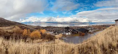 a house on a hill with a city in the background at Hilltop Vistas Kelowna in Kelowna