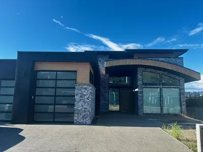 a house with two garage doors and a sky at Hilltop Vistas Kelowna in Kelowna