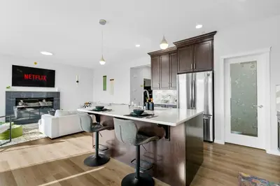 a kitchen and living room with a counter and a fireplace at The Ultimate Getaway with Central AC, 3 King Beds, Hot Tub, Pool Table and More in Balzac
