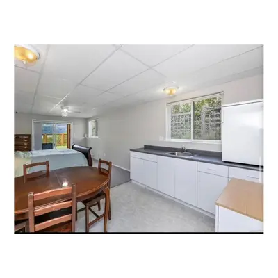 a kitchen and dining room with a table and a bed at Youbou Lakefront Getaway Relax And Unwind in Youbou