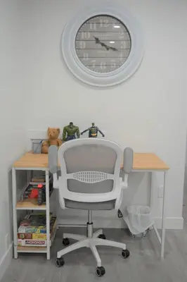 a desk with a chair and a clock on the wall at Gorgeous Two Bedroom Suite in a Quiet, Picturesque Neighborhood! in West Vancouver