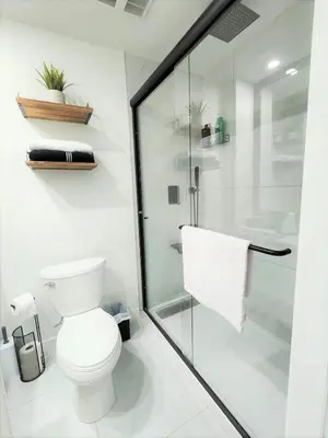 a bathroom with a toilet and a glass shower at Gorgeous Two Bedroom Suite in a Quiet, Picturesque Neighborhood! in West Vancouver