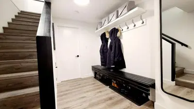 a living room with stairs and a hallway with a coat rack at Ravencrest 204 by Outpost Whistler in Whistler