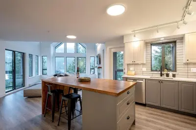 a large kitchen with a wooden island in the middle at Ravencrest 204 by Outpost Whistler in Whistler