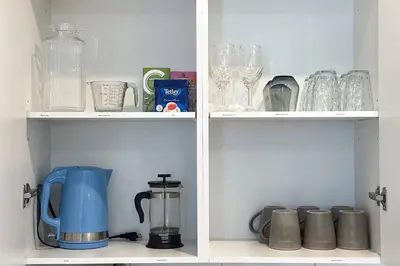 two shelves filled with glasses and a coffee maker at RomanticStylish|FreeWifi|KingBed|WEM|parking in Edmonton