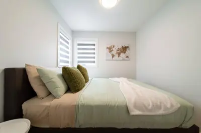 a bedroom with a bed with pillows and a window at #RusticModern3CornerSuite|KingBED|Parking|WEM|wifi in Edmonton