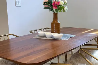 a wooden table with two bowls and a vase with flowers at #RusticModern3CornerSuite|KingBED|Parking|WEM|wifi in Edmonton