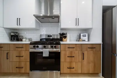 a kitchen with white cabinets and a stove top oven at ~CozySpacious3bedroomRetreat~FREEparking•2.5bath in Edmonton