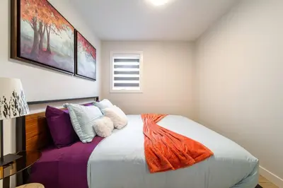 a bedroom with a large bed with colorful pillows at ~CozySpacious3bedroomRetreat~FREEparking•2.5bath in Edmonton