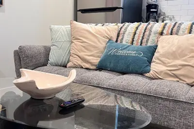 a living room with a couch and a glass table at •SteamyRomanticBsmntSuite•KingBed•Wifi•Netflix in Edmonton