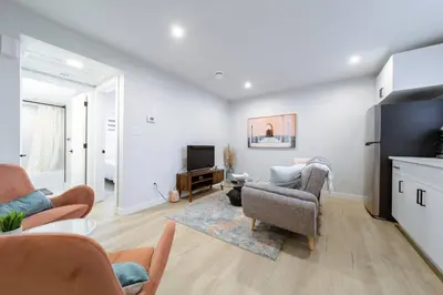 a living room with a couch and chairs and a tv at •SteamyRomanticBsmntSuite•KingBed•Wifi•Netflix in Edmonton