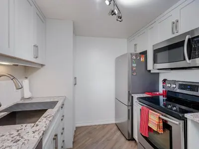 a kitchen with white cabinets and stainless steel appliances at Coastal Duet - min 3-Day Stay Breathtaking Views with Work Desk by Victoria Prime! in Victoria
