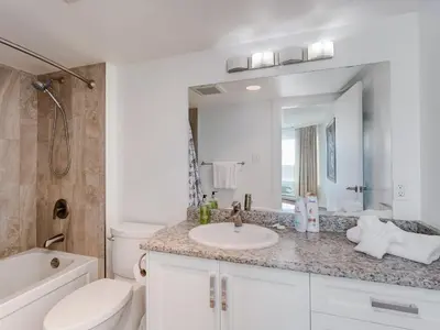 a bathroom with a sink and a toilet and a mirror at Coastal Duet - min 3-Day Stay Breathtaking Views with Work Desk by Victoria Prime! in Victoria