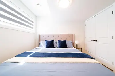a bedroom with a large bed with blue pillows at RoyalBlueBSMTsuite/KingBed/FreeParking/Netflix in Edmonton