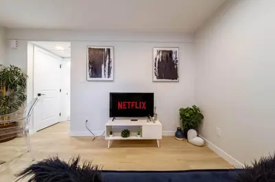a living room with a tv on a white wall at RoyalBlueBSMTsuite/KingBed/FreeParking/Netflix in Edmonton