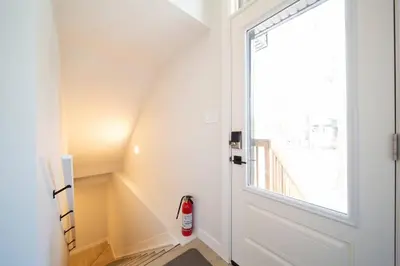 a staircase with a door and a fire extinguisher at RoyalBlueBSMTsuite/KingBed/FreeParking/Netflix in Edmonton