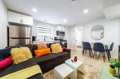 a living room with a couch and a kitchen at ~SweetTropicalBSMTsuite~KingBed|WIFI•parking in Edmonton