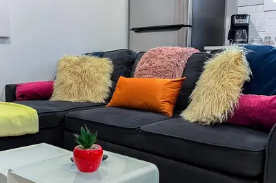 a black couch with colorful pillows on it at ~SweetTropicalBSMTsuite~KingBed|WIFI•parking in Edmonton