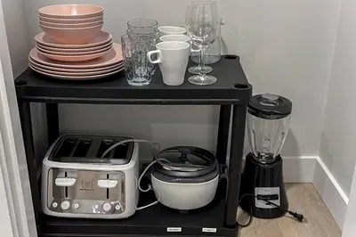 a black shelf with plates and cups and a blender at ~SweetTropicalBSMTsuite~KingBed|WIFI•parking in Edmonton