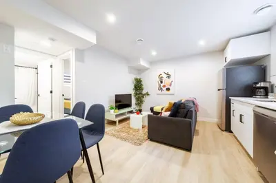 a kitchen and living room with a table and chairs at ~SweetTropicalBSMTsuite~KingBed|WIFI•parking in Edmonton