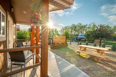 a porch with a picnic table and a bench at Prairie Junction Rustic Cabins Stettler in Stettler