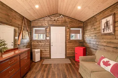 a room with a door in a log cabin at Prairie Junction Rustic Cabins Stettler in Stettler