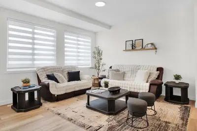 a living room with two couches and a table at Trendy & Spacious Sleeps 9 AC Db Garage in Edmonton