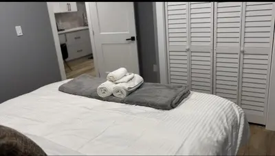 a white bed with towels on top of it at Blissful Nest - Cozy, Classy 2 Bedroom Private Suite Netflix, free Parking, 20 minutes to West Edmonton Mall and Airport in Edmonton