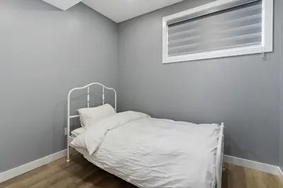a white bed in a room with a window at Blissful Nest - Cozy, Classy 2 Bedroom Private Suite Netflix, free Parking, 20 minutes to West Edmonton Mall and Airport in Edmonton