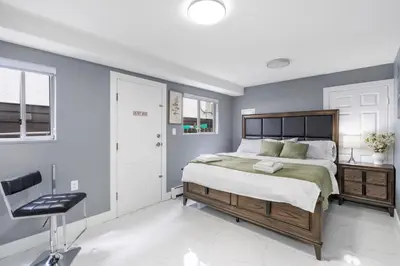 a bedroom with a bed and a chair in it at Stylish 3BR, 2BA Vancouver Home in Vancouver
