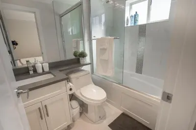 a white bathroom with a toilet and a shower at Upscale 4BR Vancouver in Vancouver