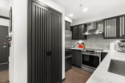 a kitchen with a black door in a kitchen at Large 1br Sub-Penthouse Near Science World in Vancouver