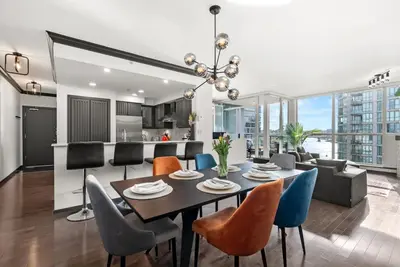 a dining room and living room with a table and chairs at Large 1br Sub-Penthouse Near Science World in Vancouver