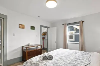 a bedroom with a bed with a pair of towels on it at Charming 2 bedroom Duplex steps from Jericho Beach in Vancouver