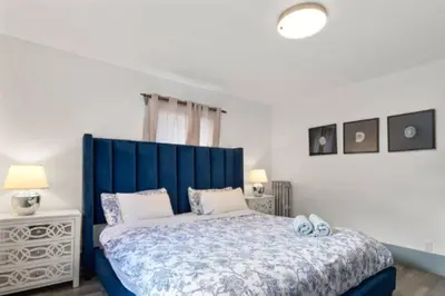 a bed with a blue headboard in a bedroom at Charming 2 bedroom Duplex steps from Jericho Beach in Vancouver