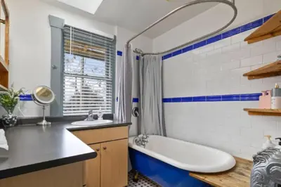 a blue and white bathroom with a tub and a sink at Charming 2 bedroom Duplex steps from Jericho Beach in Vancouver
