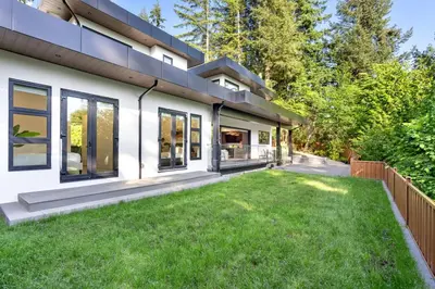 an exterior view of a house with a yard at 2505 Edgemont Blvd.- Anupoju in North Vancouver