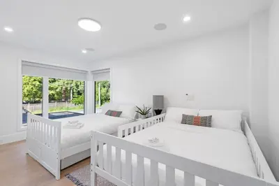 a white bedroom with two beds and a window at 2505 Edgemont Blvd.- Anupoju in North Vancouver