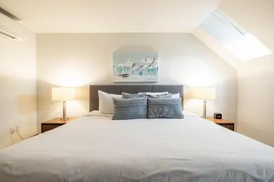 a bedroom with a large white bed with two lamps at Ravencrest 309 by Outpost Whistler in Whistler