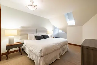 a bedroom with a large white bed and a table at Ravencrest 309 by Outpost Whistler in Whistler