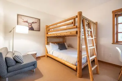 a bedroom with a bunk bed and a chair at Taluswood 6 by Outpost Whistler in Whistler