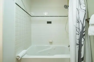 a white bath tub in a white tiled bathroom at Taluswood 6 by Outpost Whistler in Whistler