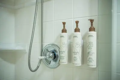 a group of three shampoo bottles on a wall in a shower at Taluswood 6 by Outpost Whistler in Whistler