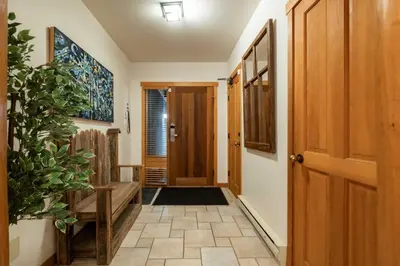 a hallway with a wooden door and a potted plant at Taluswood 14 by Outpost Whistler in Whistler
