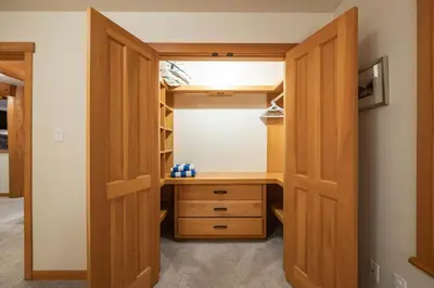 a closet with wooden doors and a desk at Taluswood 14 by Outpost Whistler in Whistler