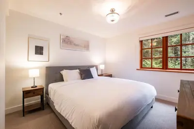 a bedroom with a large white bed and a window at Taluswood 36 by Outpost Whistler in Whistler