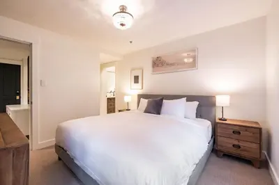 a bedroom with a large white bed and a night stand at Taluswood 36 by Outpost Whistler in Whistler