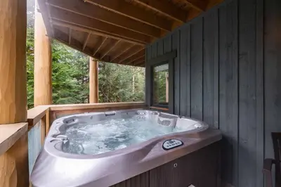a large bath tub in a cabin with a window at Taluswood 36 by Outpost Whistler in Whistler