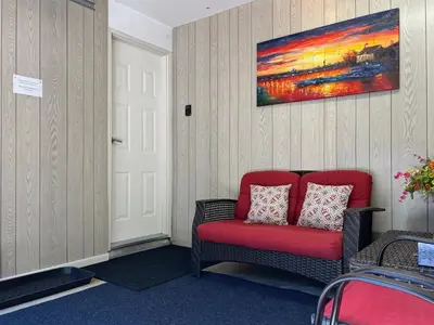 a red chair in a room with a painting on the wall at The McCleery Inn in Vancouver