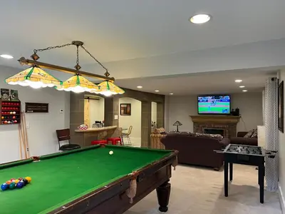 a living room with a pool table and a tv at The McCleery Inn in Vancouver